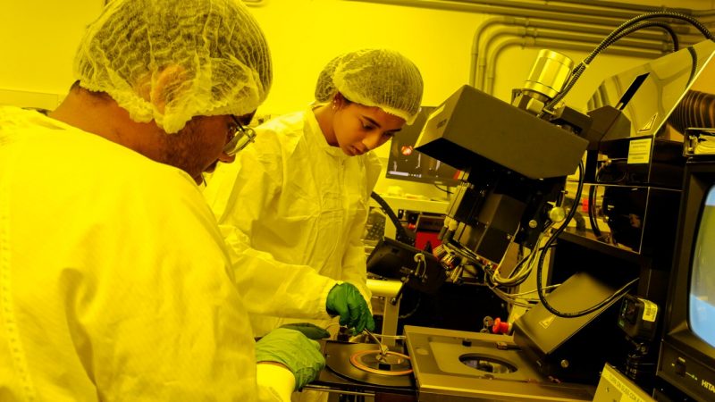 Participants in the UPWARDS summer camp fabricate semiconductors in Virginia Tech's clean lab. The clean lab uses special amber tinted lighting to protect the delicate electronics used in semiconductors. (Photo by Luke Hayes/Virginia Tech)